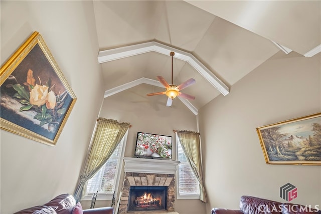 interior space featuring a fireplace, high vaulted ceiling, and ceiling fan