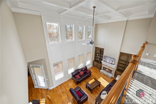 living room featuring hardwood / wood-style flooring, coffered ceiling, and beamed ceiling