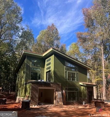 back of house featuring a garage and central AC unit