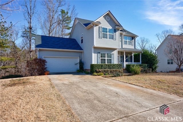 view of front property with a garage, a front yard, and covered porch