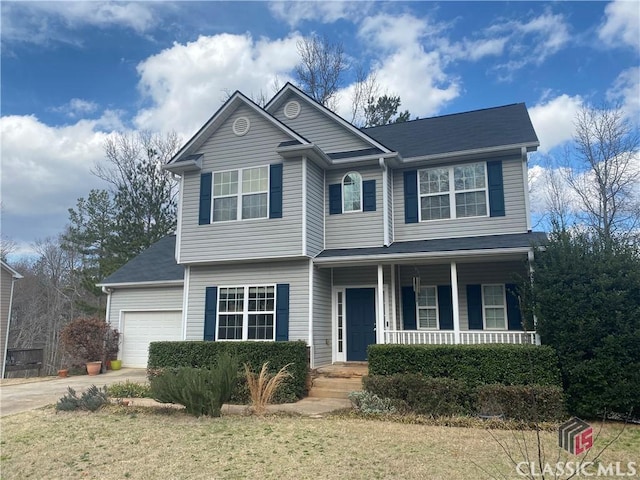 view of front of property featuring a garage, concrete driveway, and a front lawn