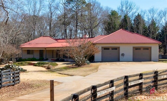 exterior space featuring a rural view, a garage, and a front lawn