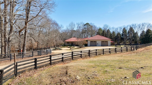 view of front facade with a rural view and fence