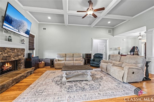 living room with ceiling fan, coffered ceiling, a fireplace, light hardwood / wood-style floors, and beamed ceiling