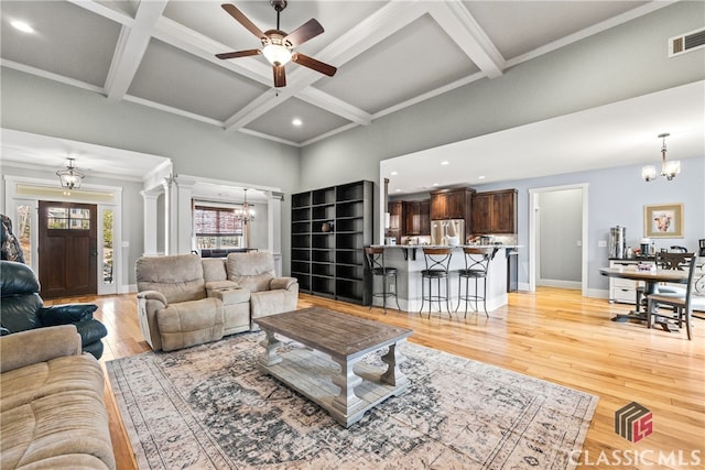 living room with ornate columns, coffered ceiling, and light wood-type flooring