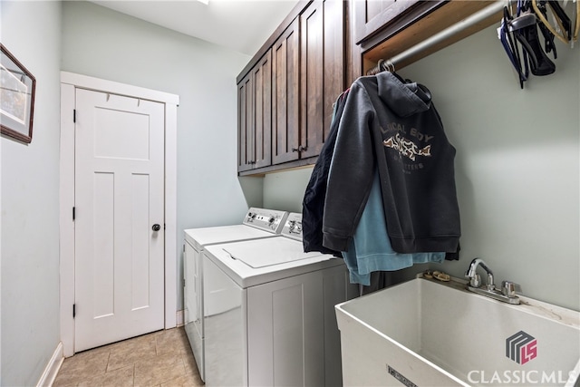 laundry area with cabinets, separate washer and dryer, sink, and light tile patterned floors