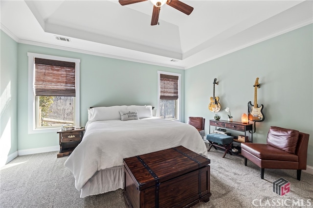 carpeted bedroom with crown molding, ceiling fan, and a tray ceiling