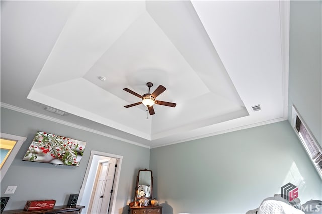 details featuring ornamental molding, ceiling fan, and a tray ceiling