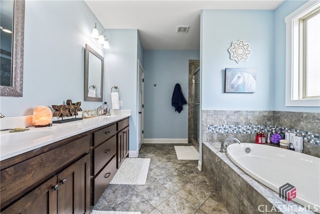 bathroom featuring vanity, independent shower and bath, and a healthy amount of sunlight