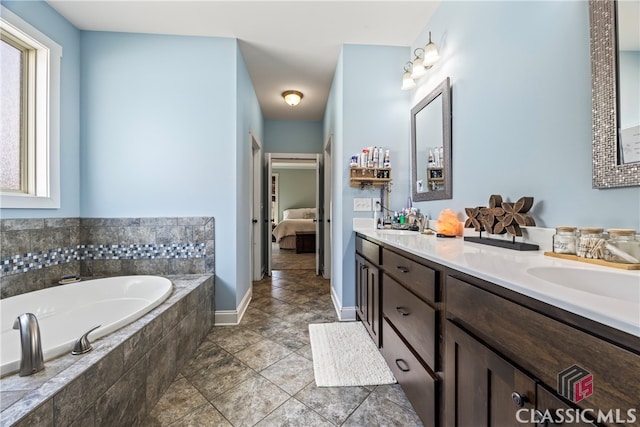 bathroom featuring vanity and tiled tub