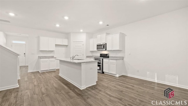 kitchen featuring stainless steel appliances, sink, a center island with sink, and white cabinets