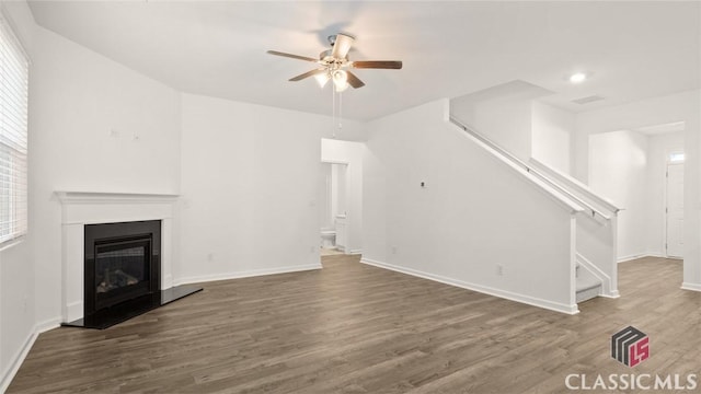 unfurnished living room with wood-type flooring and ceiling fan