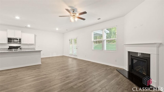 unfurnished living room with ceiling fan and dark hardwood / wood-style floors