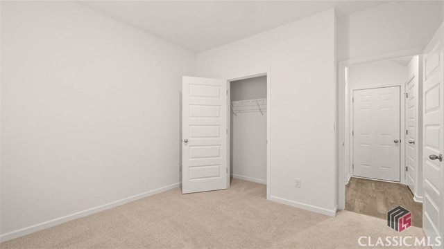 unfurnished bedroom with a closet and light carpet