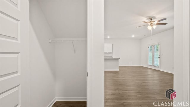 walk in closet with dark wood-type flooring and ceiling fan