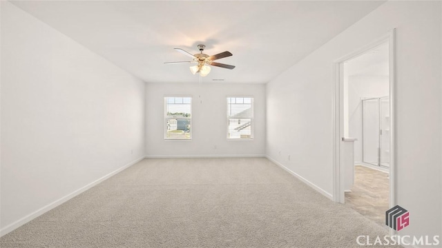 carpeted spare room with ceiling fan