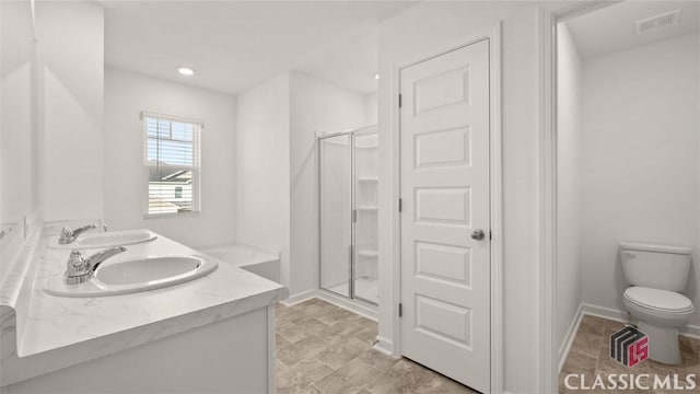 bathroom featuring vanity, toilet, and a shower with door