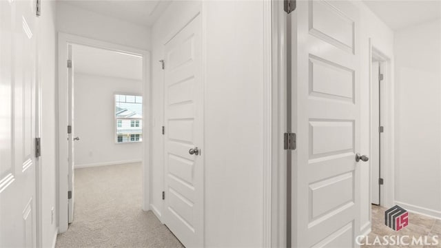 hallway featuring light colored carpet