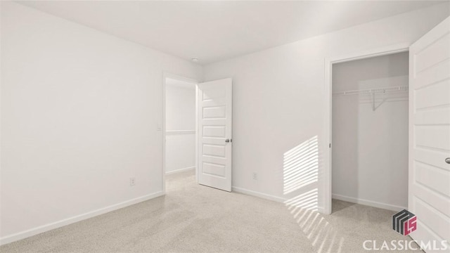 unfurnished bedroom featuring light colored carpet and a closet