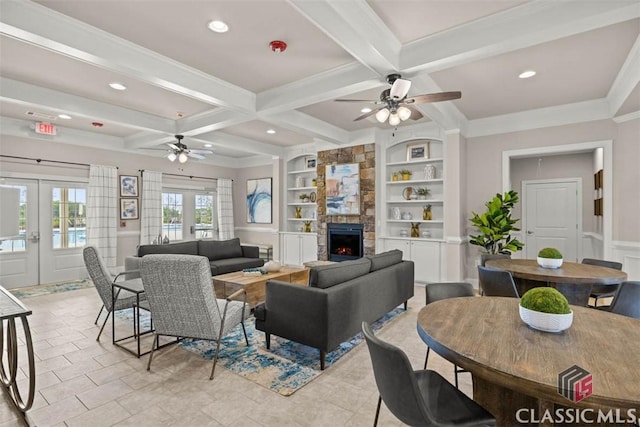 living room with beam ceiling, coffered ceiling, a fireplace, built in shelves, and french doors