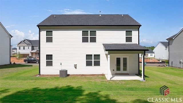 rear view of property featuring a yard, central AC unit, and a patio area