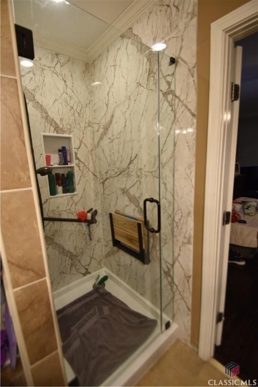 bathroom with ornamental molding and a shower with shower door