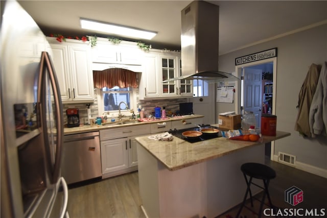 kitchen with sink, a breakfast bar area, white cabinetry, island exhaust hood, and stainless steel appliances