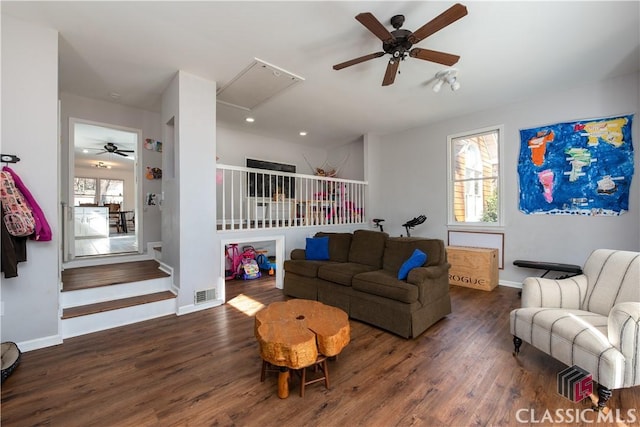 living room featuring dark hardwood / wood-style flooring, ceiling fan, and a healthy amount of sunlight