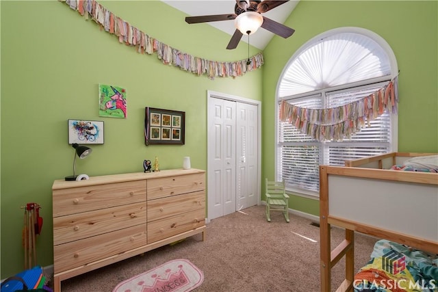 carpeted bedroom with vaulted ceiling, ceiling fan, and a closet