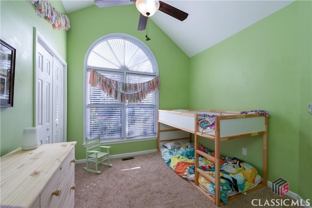 carpeted bedroom with ceiling fan, lofted ceiling, and a closet