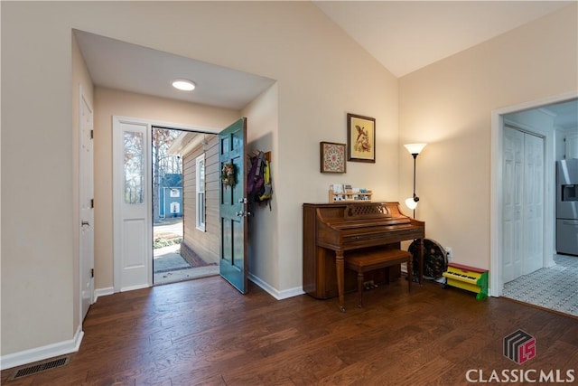 entrance foyer with dark hardwood / wood-style flooring and vaulted ceiling