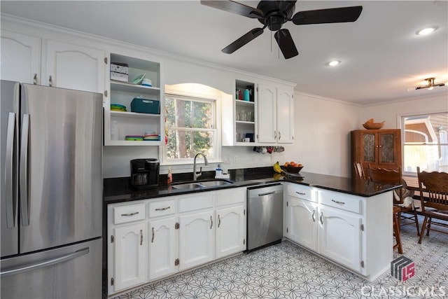 kitchen with sink, kitchen peninsula, white cabinets, and appliances with stainless steel finishes