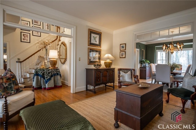 sitting room featuring ornamental molding, a chandelier, and hardwood / wood-style floors