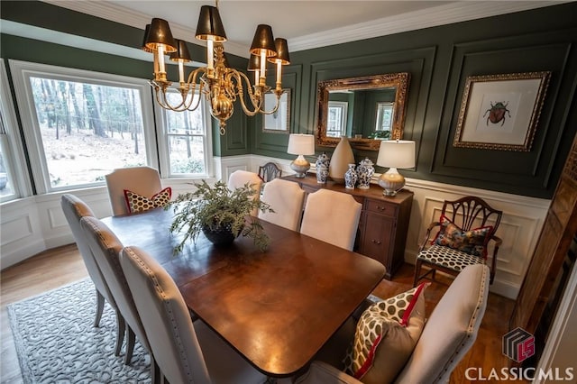 dining area featuring an inviting chandelier, ornamental molding, and light hardwood / wood-style floors