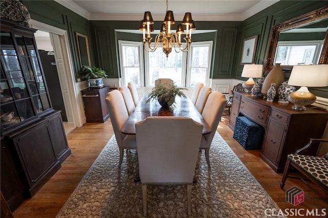 dining area featuring ornamental molding, a healthy amount of sunlight, and light hardwood / wood-style flooring