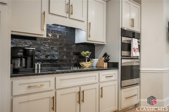 kitchen with tasteful backsplash, black electric stovetop, dark stone countertops, and double oven