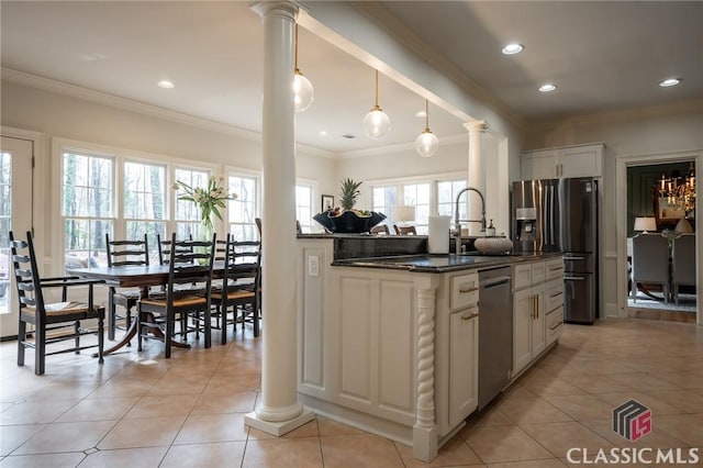 kitchen featuring pendant lighting, dark stone countertops, stainless steel appliances, and ornate columns