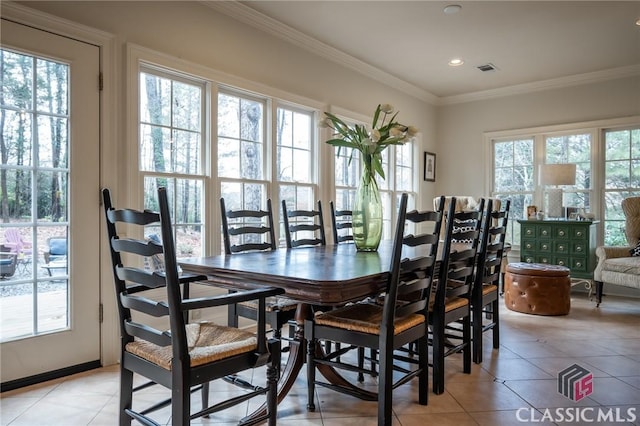 dining space with light tile patterned floors, crown molding, and a healthy amount of sunlight