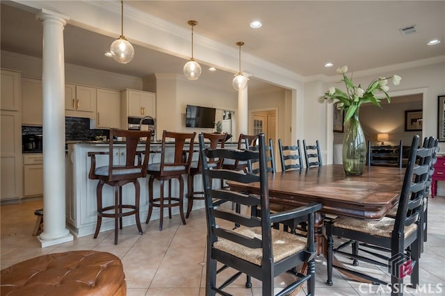 tiled dining room featuring ornamental molding and ornate columns