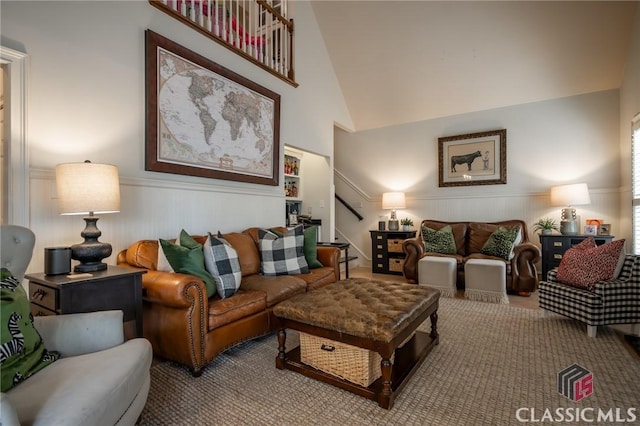 living room featuring high vaulted ceiling and carpet