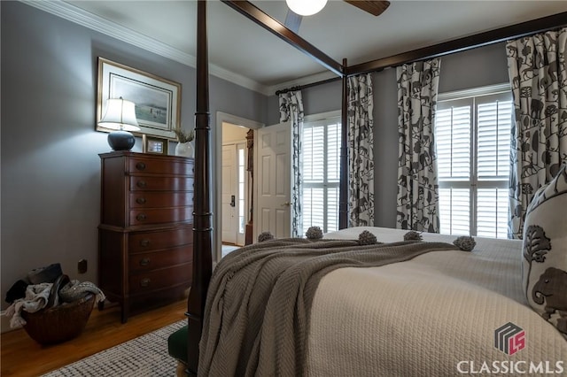 bedroom featuring hardwood / wood-style flooring, ceiling fan, and ornamental molding