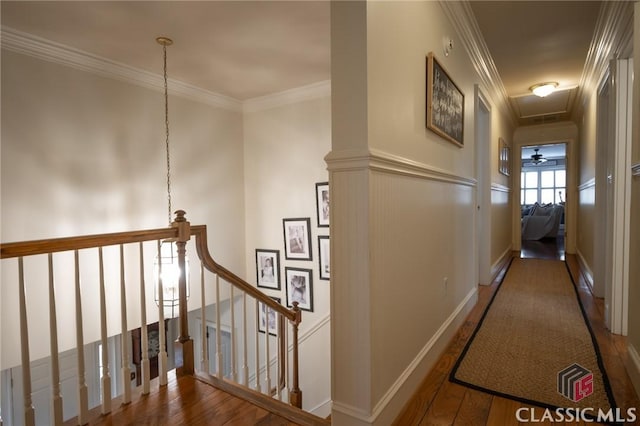 corridor with ornamental molding and hardwood / wood-style floors