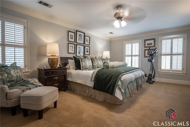 carpeted bedroom with ornamental molding and ceiling fan