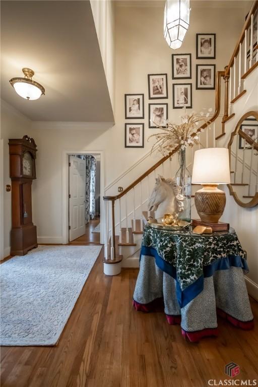 foyer entrance featuring wood-type flooring and ornamental molding