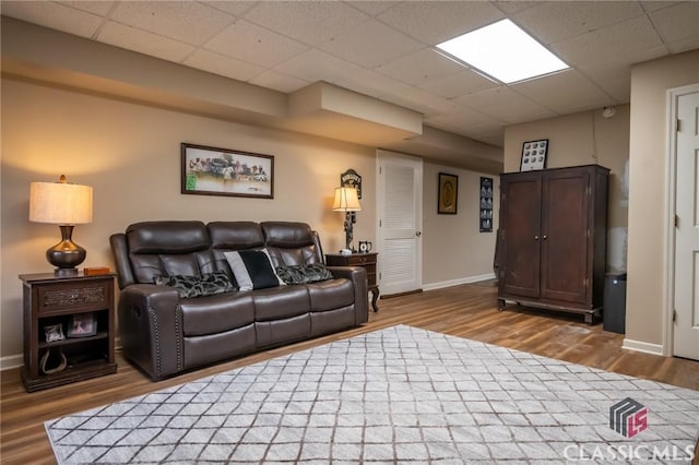 living room featuring a paneled ceiling and wood-type flooring