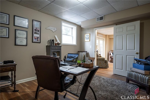 office space featuring a drop ceiling and wood-type flooring