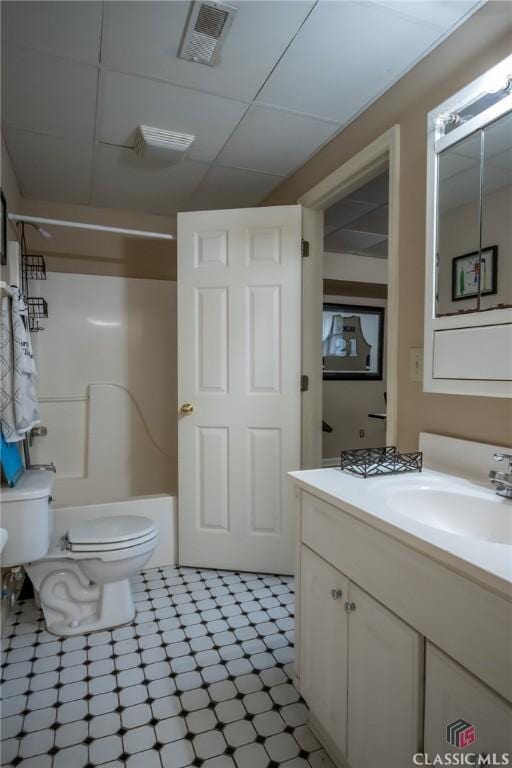 full bathroom with vanity, toilet, tub / shower combination, and a drop ceiling