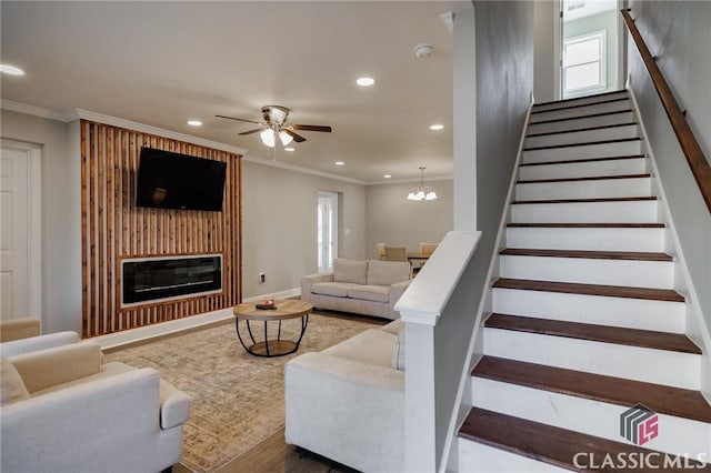 living room featuring crown molding, ceiling fan with notable chandelier, and hardwood / wood-style flooring