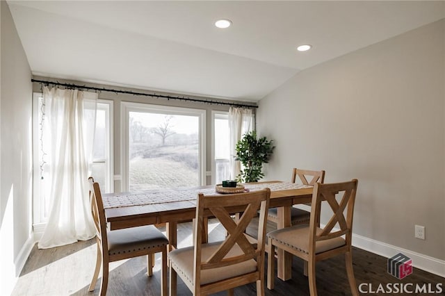 dining room with vaulted ceiling and hardwood / wood-style floors