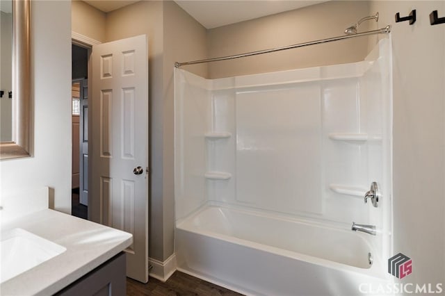 bathroom with hardwood / wood-style flooring, vanity, and  shower combination